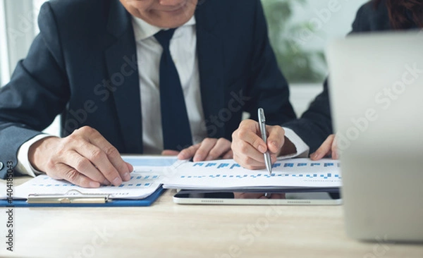 Fototapeta Two Business person at meeting room, using digital tablet discussing business report at office with documents on desk, meeting to planning analyzing the financial report, finance analysis concept