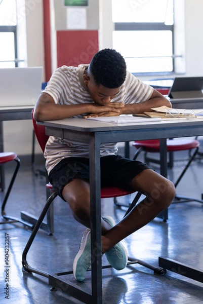 Obraz Sleeping at desk, student in school classroom during daytime, feeling tired