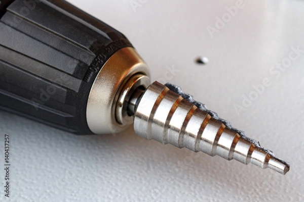 Obraz Step drill in the chuck of the screwdriver