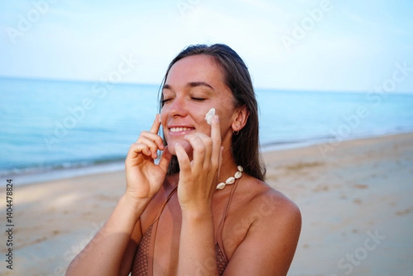 Obraz Portrait of tanned happy satisfied smiling young brunette woman with spf sunscreen lotion on face. Uv protection and skin care, healthy skin