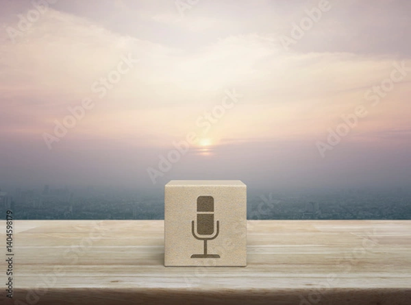Obraz Microphone flat icon on wood block cube on wooden table over city tower and skyscraper at sunset, vintage style, Business communication concept