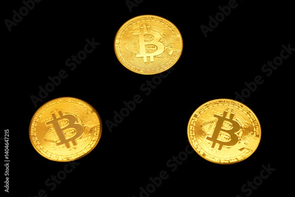 Fototapeta Three golden Bitcoin coins on a black background, symbolizing cryptocurrency and digital finance. The image highlights the growing relevance of Bitcoin in the financial world.