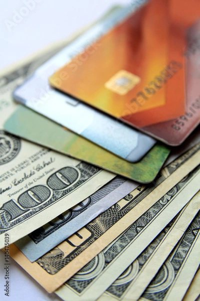 Fototapeta Stack of plastic bank credit cards and dollars, close-up view. Vertical business background.