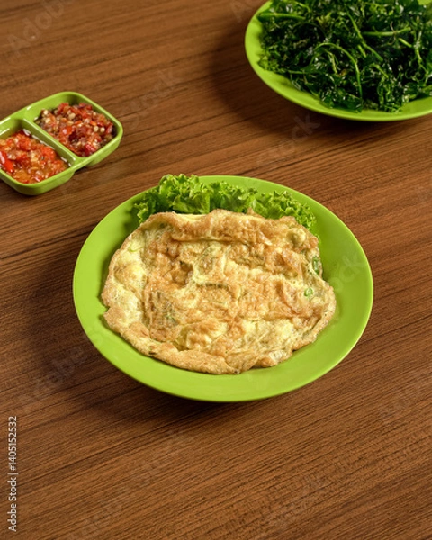 Fototapeta Indonesian Omelette Served With Fresh Vegetables And Spicy Sambal On The Side, A Traditional Meal Of Flavor And Local Culinary Character.