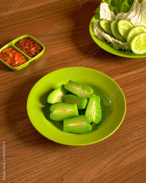 Fototapeta Steamed Pumpkin Served with Fresh Vegetables and Spicy Sambal on the Side, A Nutritious Traditional Indonesian Plant-Based Meal Option.