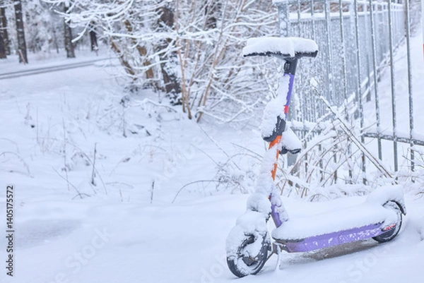 Obraz Winter s stillness blankets a forgotten electric scooter, a poignant scene of urban life paused by heavy snowfall, evoking a sense of quiet isolation.