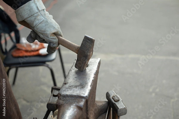 Fototapeta Blacksmith hits anvil. Hammer and anvil. Metal Processing Details.