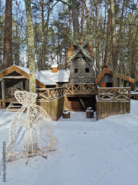 Fototapeta Tiny dwarf village hidden in the forest. Snow covered elf houses. Whimsical travel place. Windmill at the thematic park.