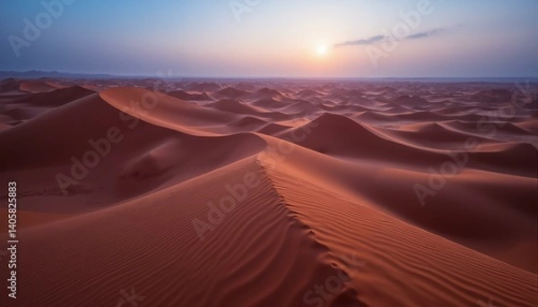 Fototapeta Vast sand dunes in warm tones meet a hazy twilight sky, creating a serene and solitary scene.