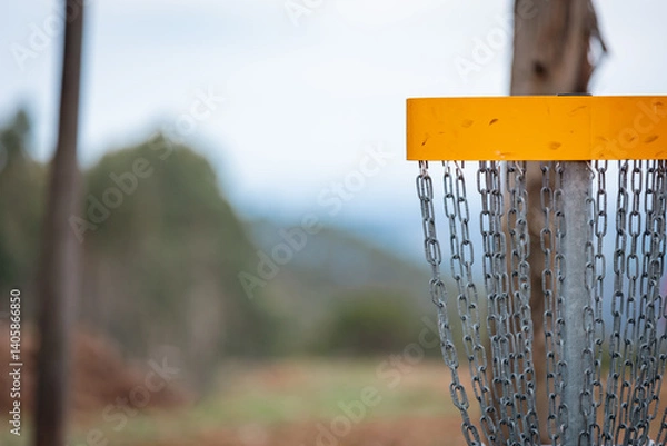 Obraz Yellow disc golf basket and blurred backgound.