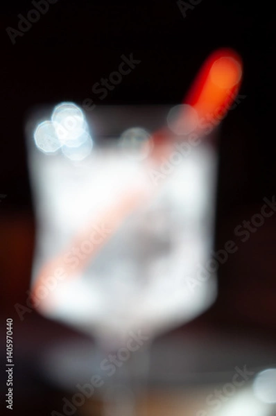 Obraz Refreshing drink with ice and a vibrant stirrer in a cozy bar setting at night