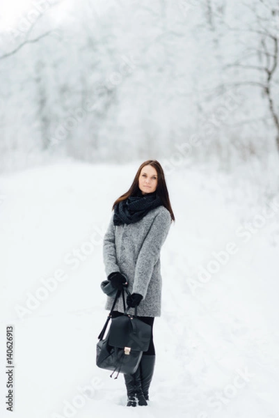 Fototapeta Portrait of a brunette wearing glasses and a gray coat