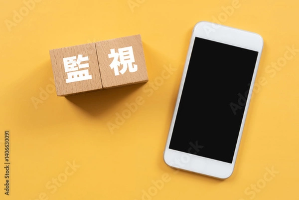 Obraz 監視と書かれたブロックとスマホ