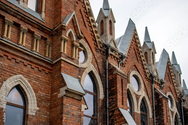 Obraz Architectural styles of the Catholic Church, view from below. Fragment of the decoration of the church in the neo-Gothic style. Roman Catholic church made of brick in the neo-Gothic style