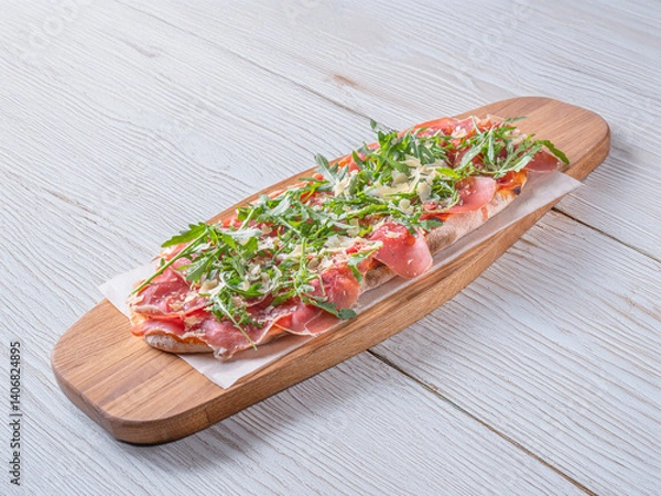 Obraz Pizza Parma. Pizza Prosciutto. Freshly baked Pizza Parma with a thin crispy crust, topped with prosciutto, arugula, and shaved Parmesan. Served on a rustic wooden board with a dark background