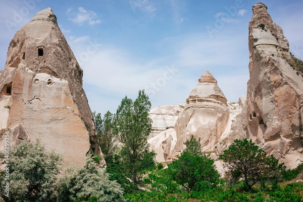 Obraz A scenic valley with unique rock formations, green trees, and blue sky in daylight. This image represents nature, geology, outdoor tourism, and landscape photography.