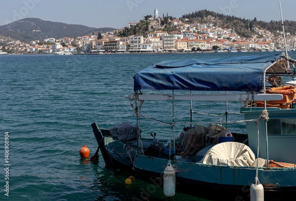 Fototapeta A small fishing vessel is moored close-up near the shore on a sunny, spring day