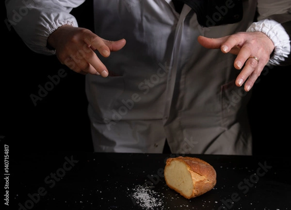 Obraz Salting bread on black background, concept