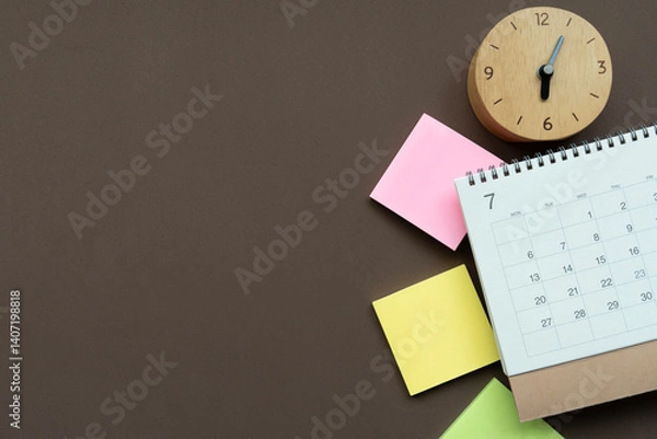 Fototapeta close up of calendar and clock on the brown table background, planning for business meeting or travel planning concept