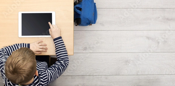 Fototapeta young kid at school behind desk