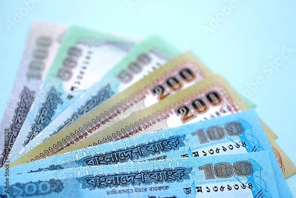 Obraz Bangladeshi taka money bills in big amount lies on teal color table close up