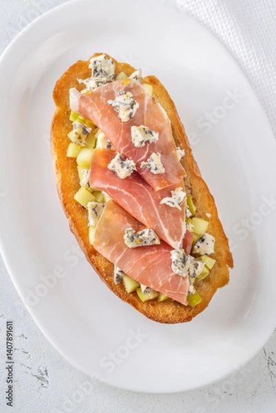 Obraz Toasted sandwich with blue cheese, prosciutto, sautéed apple, honey, white plate