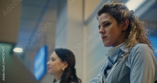 Fototapeta International Airport Terminal: Close Up of Female Airline Worker Talking and Checking Documents of Passenger at Airport Check-in Counter. Passport Control at Security Checkpoint for Boarding Flight.