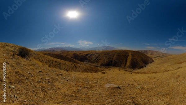 Obraz Dry, open landscape with rolling hills under a bright sun.