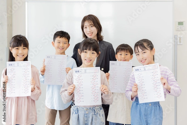 Obraz テストで満点を取った小学生と塾の講師
