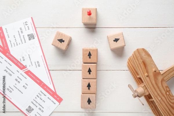 Fototapeta Cubes with tickets and toy airplane on white wooden background. Itinerary concept