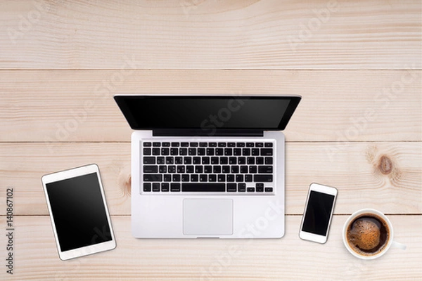 Fototapeta Top view laptop computer or notebook,mobile phone and cup of coffee on wooden table. Business template mock up for adding your text.