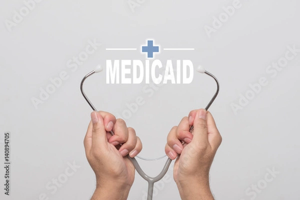 Obraz Hands holding a stethoscope and word "MEDICAID"  medical concept.