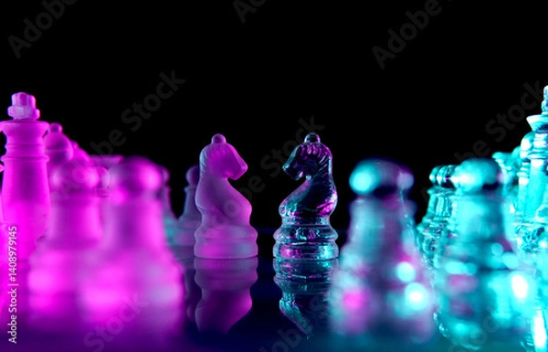 Fototapeta two glass chess knights facing each other
