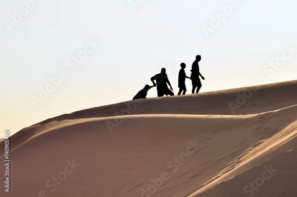 Obraz Silhouette of Family Climbing Sand Dune