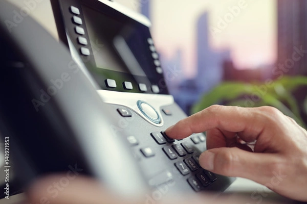 Fototapeta Dialing a telephone in the office