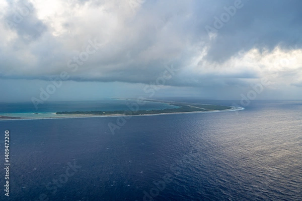 Fototapeta Aerial view of Tikehau atoll, French Polynesia, with cloudy sky and lagoon