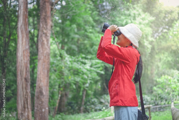 Obraz Little girl looking through a binoculars searching for an imagination or exploration in summer day in park.