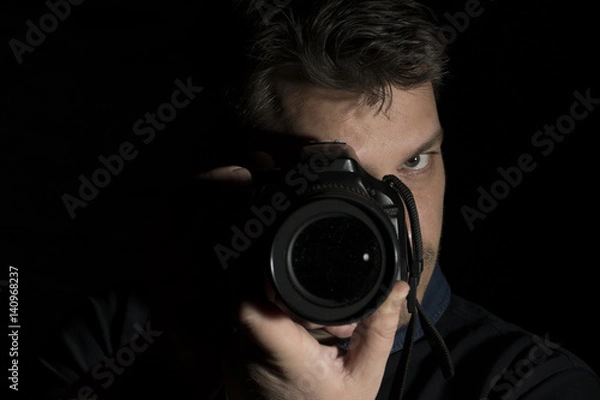 Obraz Young man as a photographer portrait isolated on black background