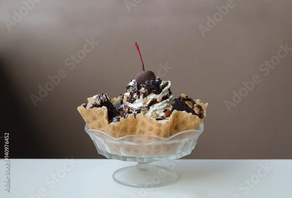 Fototapeta Ice Cream Sundae in an edible waffle bowl with brownies, almonds