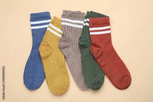 Obraz Many different pairs of socks on beige background, flat lay