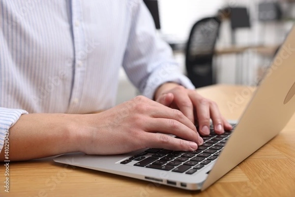 Obraz Man working on laptop at wooden desk in office, closeup