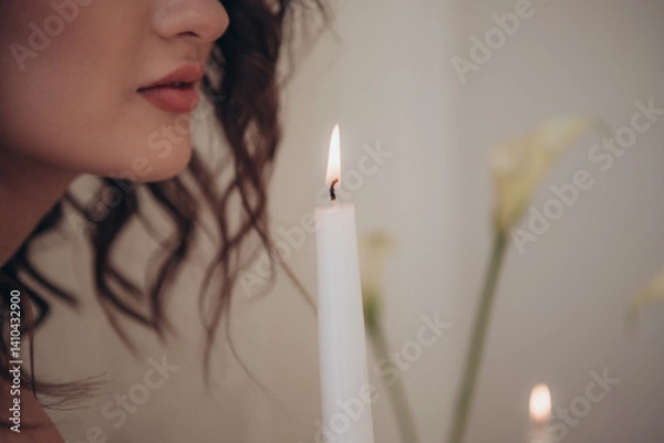 Fototapeta Close-up of a woman’s lips and candlelight with delicate romantic floral elements