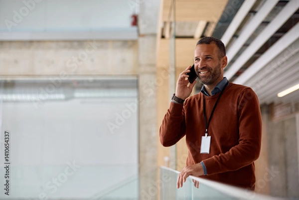 Obraz Happy entrepreneur making phone call while working in office.