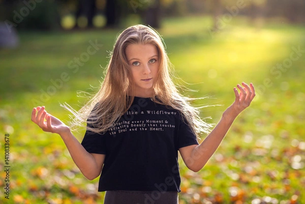 Fototapeta Beautiful young woman with autumn yellow leaves. Portrait of joyful woman playing with tree leaves in park during autumn. Happy girl wearing leather jacket and sunglasses and playing with leaves.