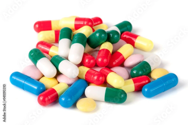 Fototapeta pile of colorful pills isolated on white background