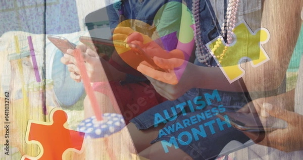 Fototapeta Image of colourful puzzle pieces and autism text over friends using smartphone and tablet