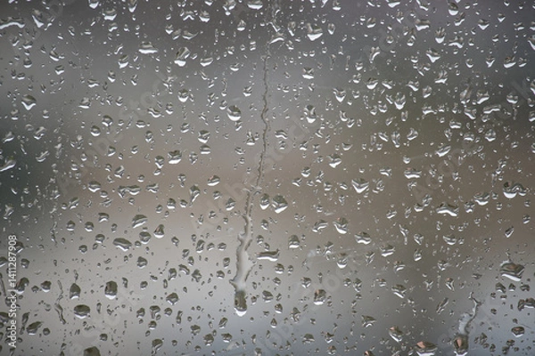 Fototapeta A close-up view of raindrops creating an artistic pattern on a window, a rainy day.