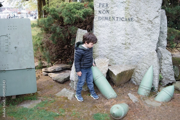 Fototapeta Child explores historical war relics in a park