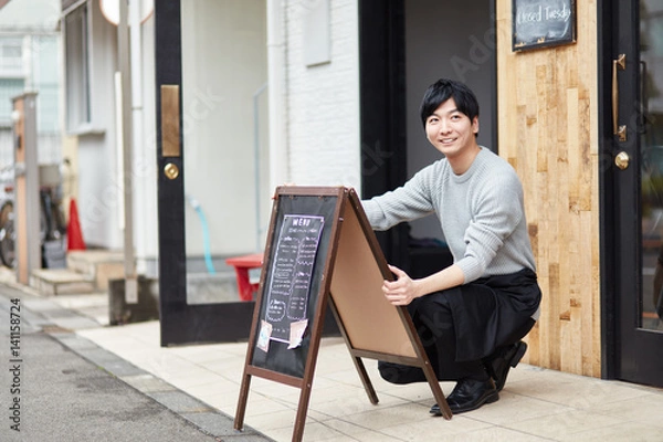 Obraz 看板を出すカフェ店員