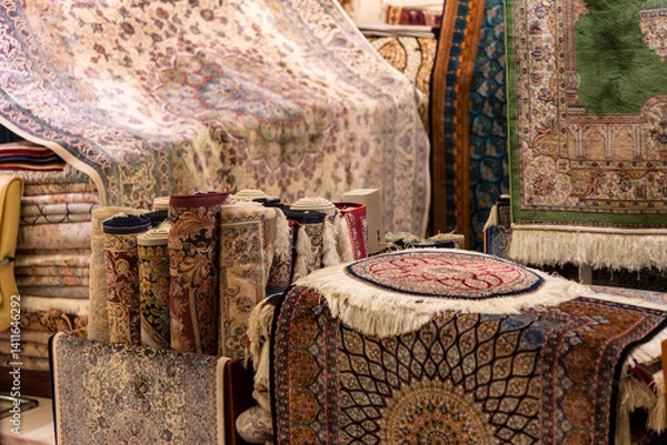 Fototapeta Interior of a shop filled with Iranian silk carpets in various colors and intricate patterns, showcasing the richness of traditional craftsmanship.